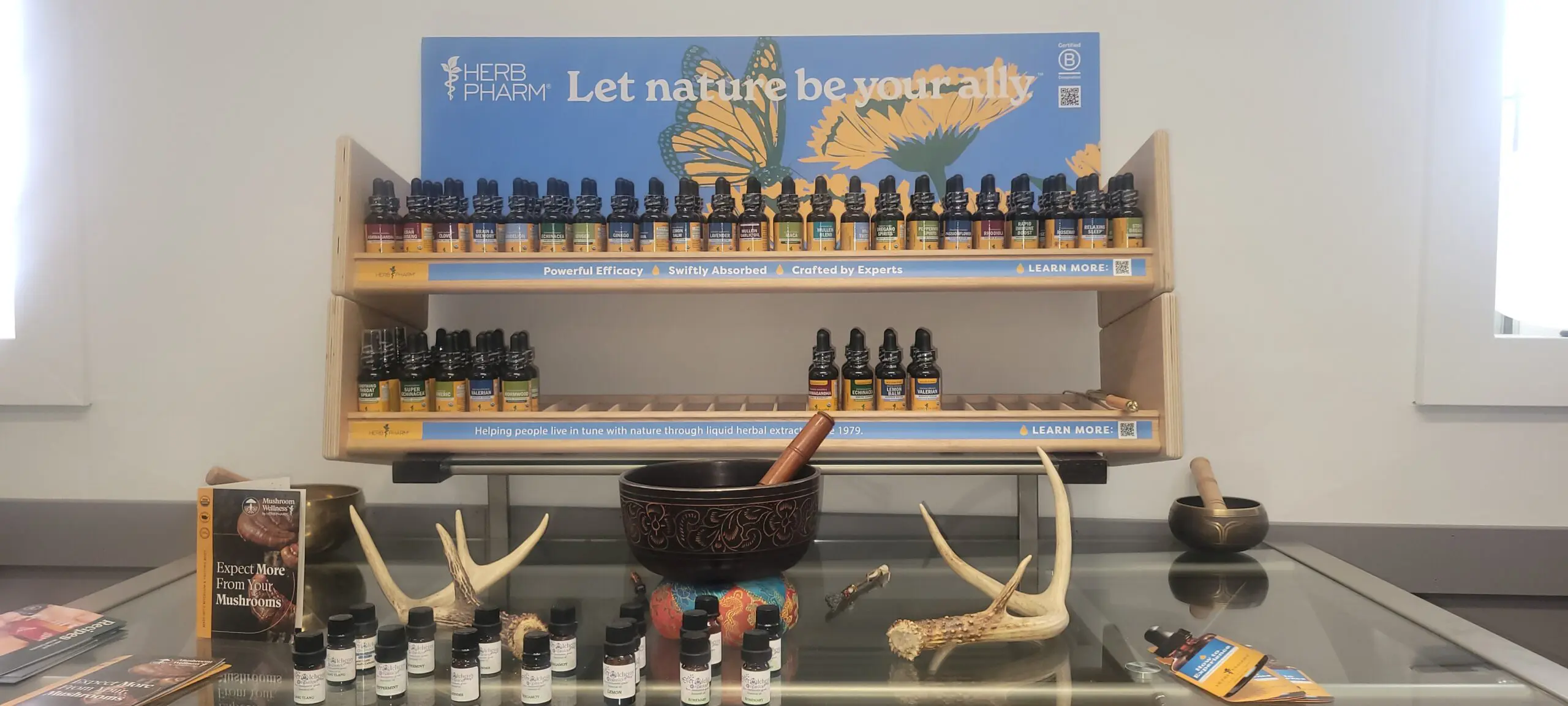 Natural wellness oils and accessories displayed with antlers and a mortar.