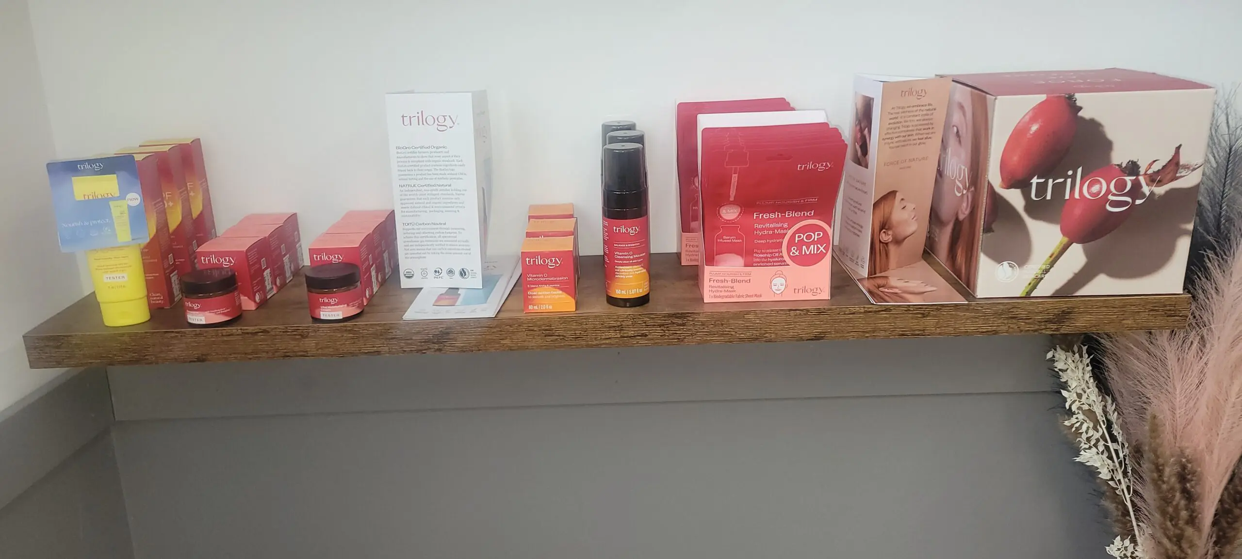A shelf displaying various skincare and beauty products in red and white packaging.