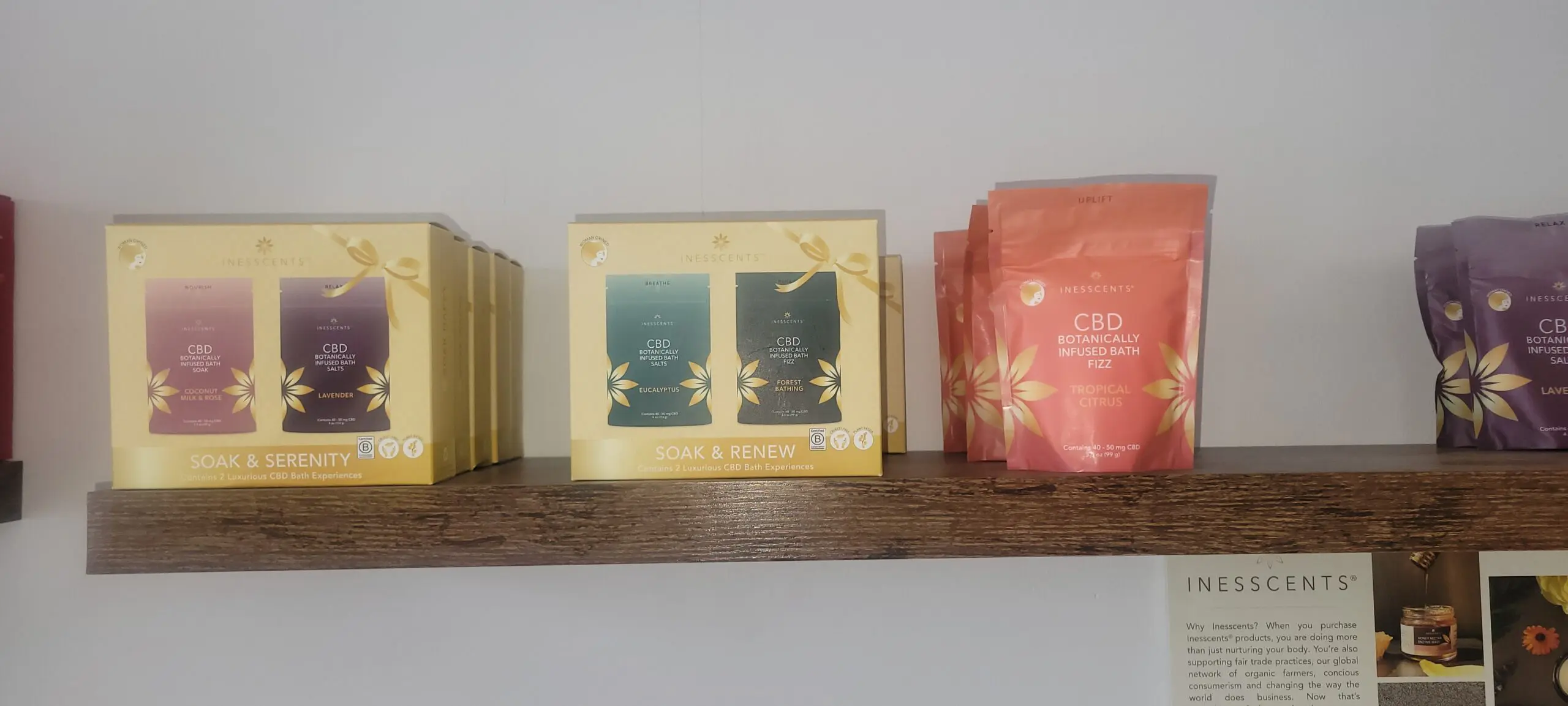 A shelf displaying decorative scented candles in pastel packaging.