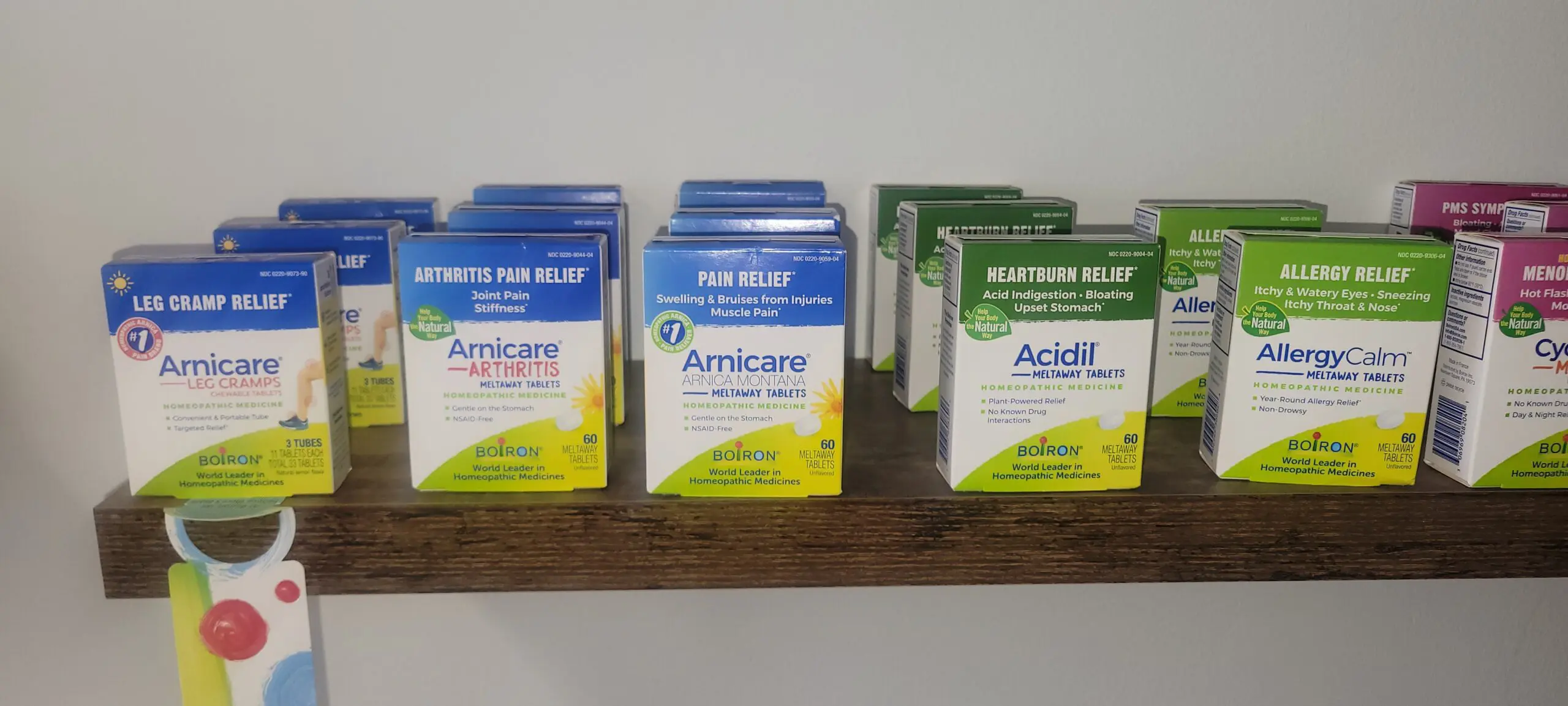 Three types of digestive relief medicines on a wooden shelf.