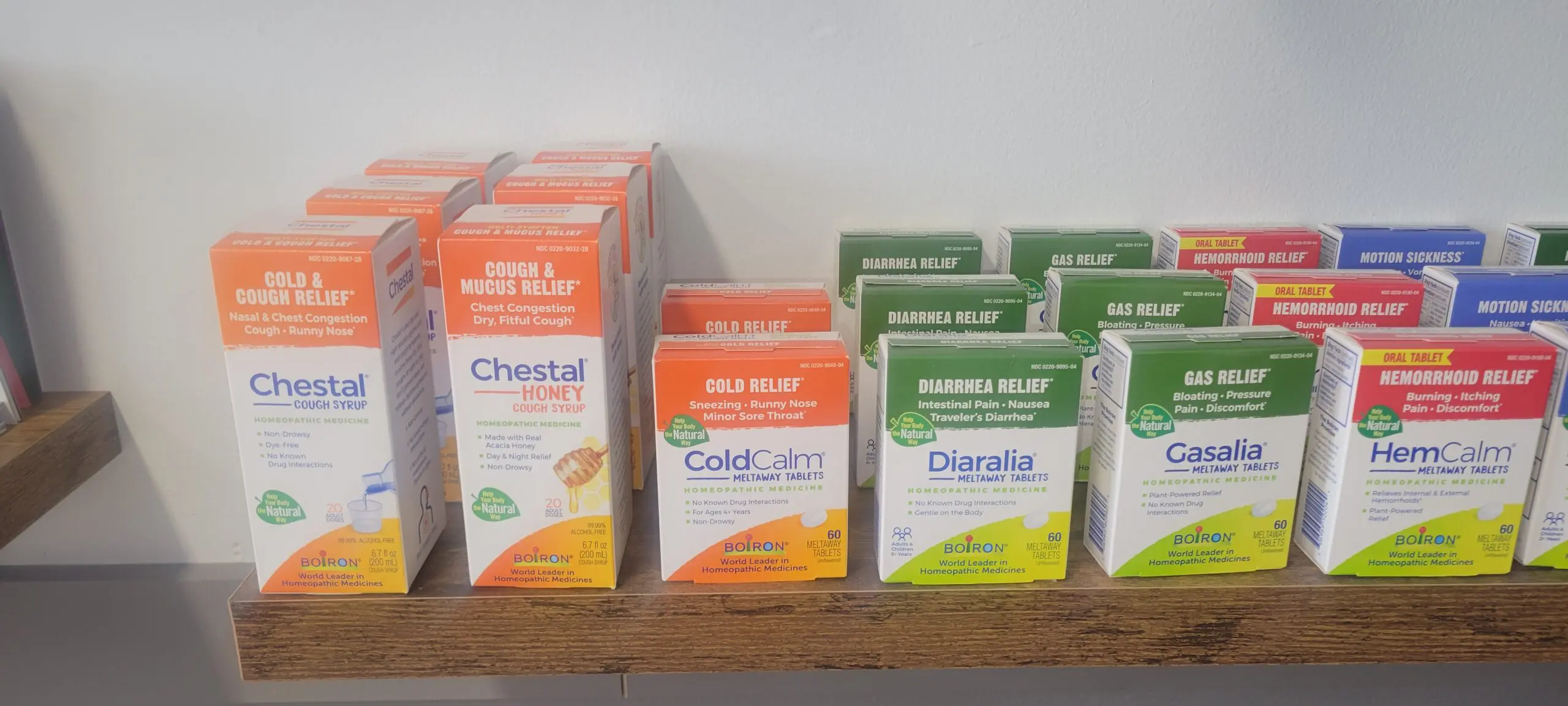 Various cough and cold medications displayed on a shelf.