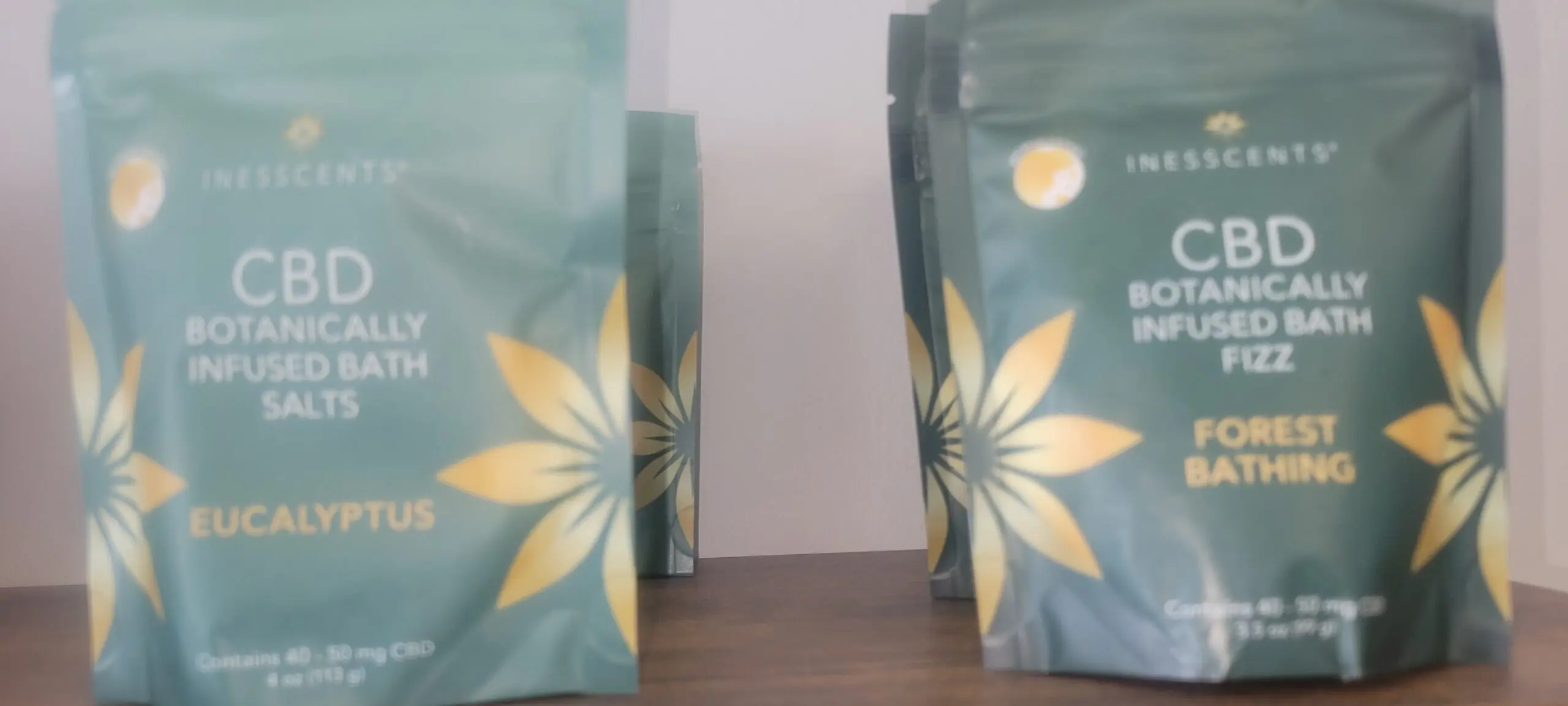 Two floral-patterned bags on a wooden surface with a white background.