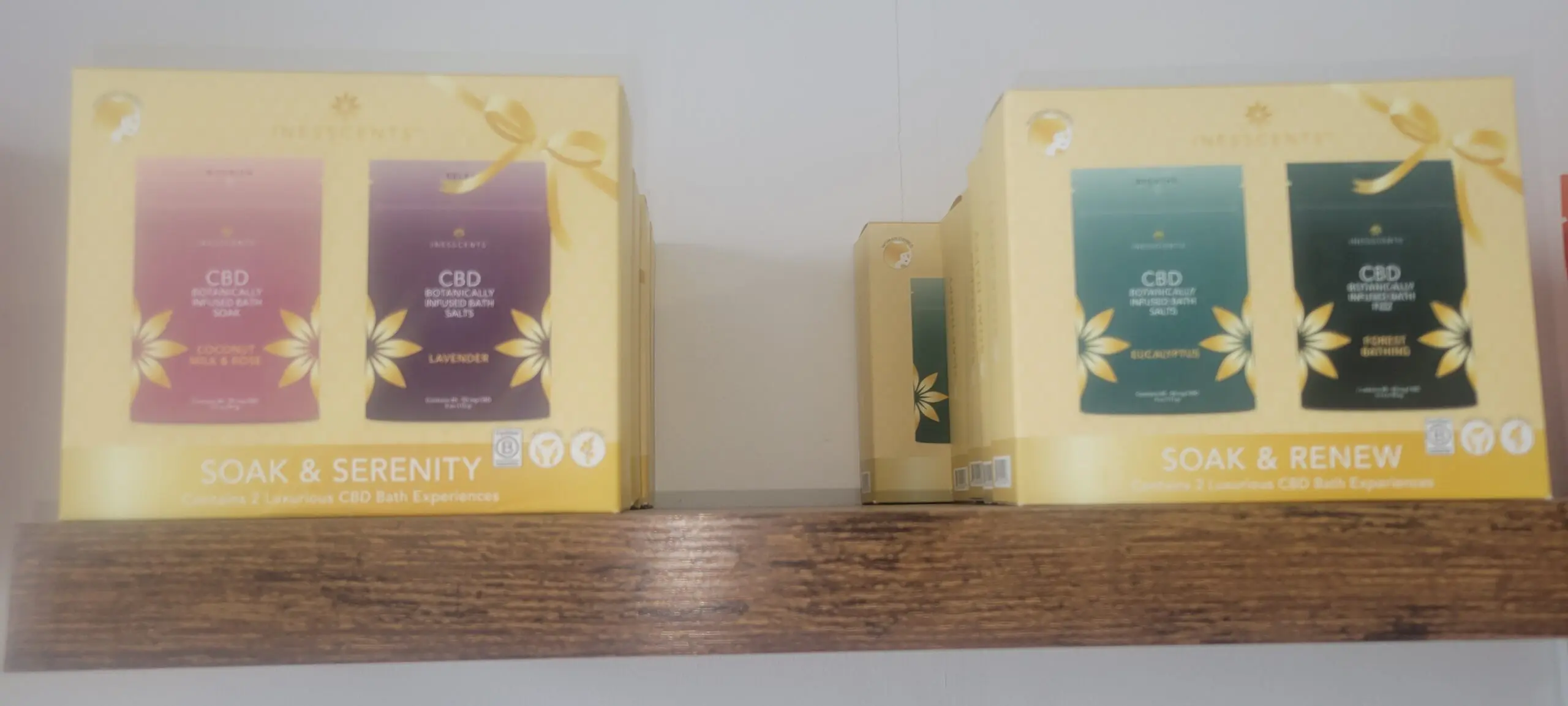 Yellow packaging boxes displayed on a wooden shelf.