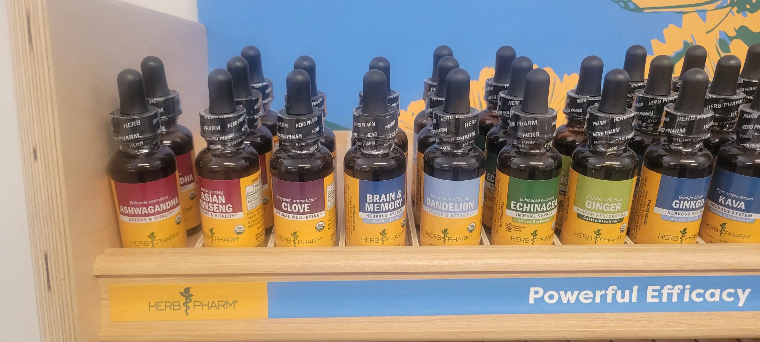 Rows of colorful CBD vape oil bottles on a store shelf.