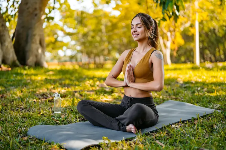 Woman practicing yoga outdoors in nature.