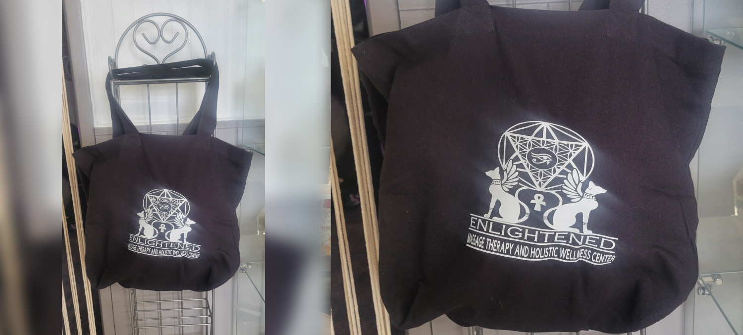Black hoodie with a graphic design on the back hanging on a rack.